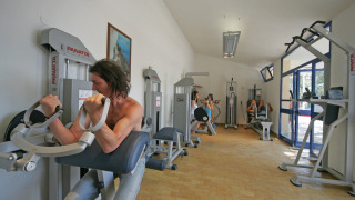 Gimnasio con personas entrenando en máquinas en Camping Village Mare Pineta, Friuli-Venezia Giulia, Italia.