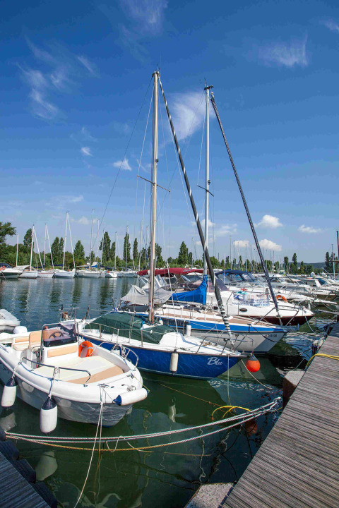 Barche a vela e motoscafi ormeggiati al molo del Camping Village Mare Pineta, Friuli-Venezia Giulia, Italia.