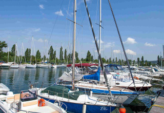 Sejlbåde og motorbåde fortøjet ved en bådebro på Camping Village Mare Pineta i Friuli-Venezia Giulia, Italien.