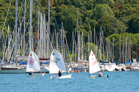Kinderen zeilen met kleine bootjes bij een jachthaven aan Camping Village Mare Pineta in Italië.