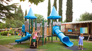 Niños juegan en un colorido parque infantil con toboganes en Altomincio Family Park, Lombardía, Italia.