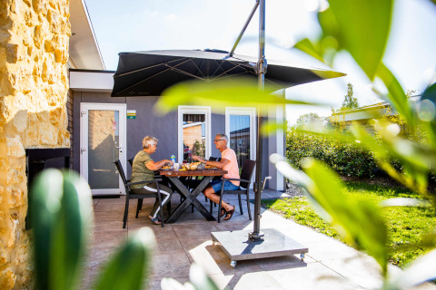 Pareja mayor disfruta de una comida al aire libre en Resort Mooi Bemelen, parque vacacional en Limburg, Países Bajos.