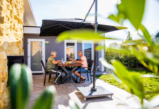 Ouder koppel eet samen buiten op het terras bij vakantiepark Resort Mooi Bemelen in Limburg, Nederland.