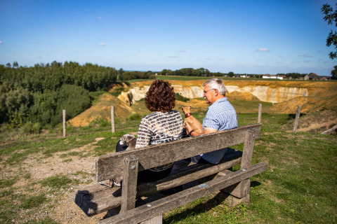 Zwei Personen sitzen auf einer Bank im Resort Mooi Bemelen, Limburg, Niederlande, mit Blick auf die Umgebung.