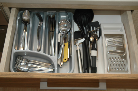 Cubiertos y utensilios de cocina organizados ordenadamente en un cajón de un alojamiento glamping.