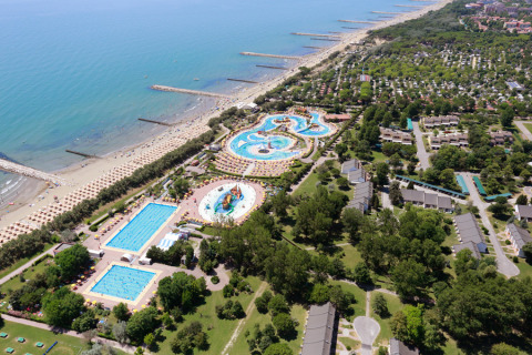 Vista aérea de Camping Pra’delle Torri en Véneto, Italia, con piscinas, playa y alojamientos vacacionales.