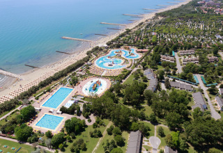 Aerial view of Camping Pra’delle Torri in Veneto, Italy, featuring pools, beach and holiday accommodations.