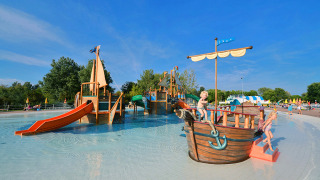 Zona acuática con barco pirata y toboganes para niños en Camping Pra'delle Torri, Veneto, Italia.