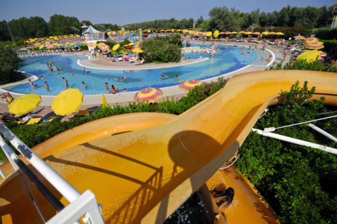 Vue sur un toboggan aquatique et piscines au Camping Pra'delle Torri, parc de vacances en Vénétie, Italie.