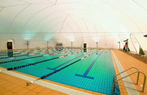 Piscina cubierta con carriles de natación y modernas luces en Camping Pra'delle Torri, Veneto, Italia.
