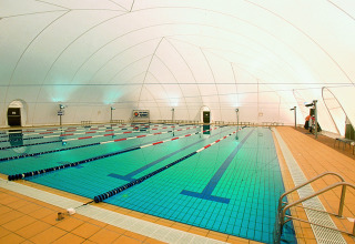 Piscina coperta con corsie e illuminazione moderna presso Camping Pra'delle Torri, Veneto, Italia.