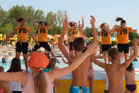 Kinderen en tieners doen mee aan een zwembad-aerobics bij Camping Pra'delle Torri in Veneto, Italië.