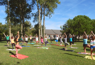 Udendørs yoga på græsplæne ved Camping Pra'delle Torri, feriepark i Veneto, Italien, solrig dag.