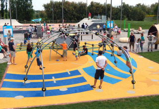 Bambini e adulti giocano su un colorato parco giochi a Camping Pra'delle Torri, Veneto, Italia.