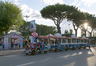 Children’s train ride at Camping Pra'delle Torri in Veneto, Italy, with families enjoying the afternoon sun.