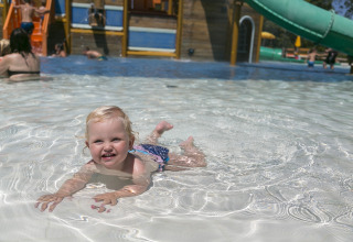 Un bambino piccolo gioca e nuota nella piscina bassa al Camping Pra'delle Torri, un villaggio vacanze in Veneto, Italia.
