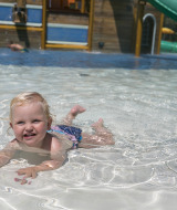 A young child plays and swims in the shallow pool at Camping Pra'delle Torri holiday park in Veneto, Italy.