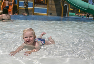 Een klein kind speelt en zwemt in het ondiepe zwembad van Camping Pra'delle Torri in Veneto, Italië.