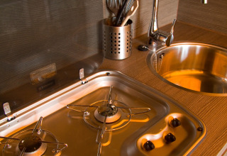 Moderne keuken in SunLodge Safari op Camping Pra'delle Torri, Italië, met gasvuur en spoelbak.