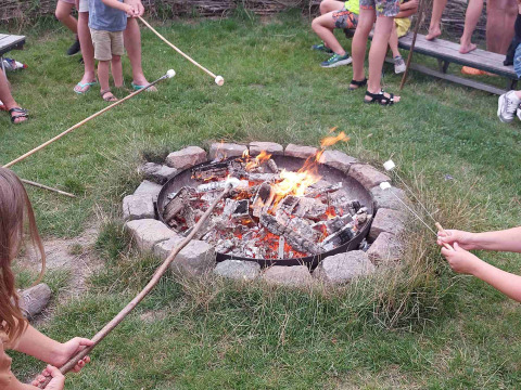 Bambini che arrostiscono marshmallow intorno al fuoco al Camping De Gouwe Stek, in Olanda Settentrionale.