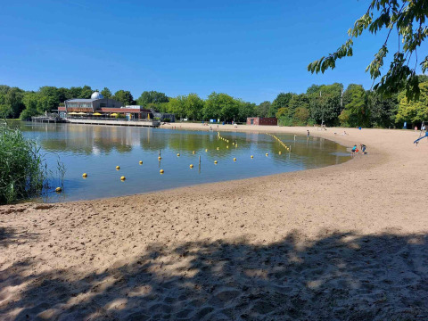 Playa de arena y agua tranquila en Camping De Gouwe Stek, parque vacacional en Holanda Septentrional, Países Bajos.