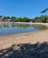 Playa de arena y agua tranquila en Camping De Gouwe Stek, parque vacacional en Holanda Septentrional, Países Bajos.