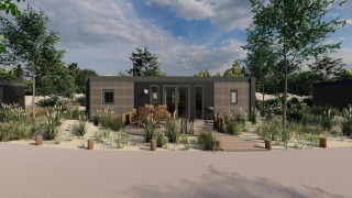Casa tipo lodge moderna con terraza de madera, muebles exteriores y rodeada de arena y vegetación.