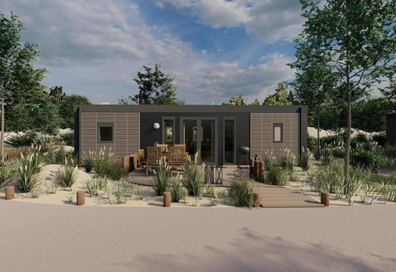 Casa tipo lodge moderna con terraza de madera, muebles exteriores y rodeada de arena y vegetación.