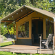 Tienda safari Stoere con terraza cubierta, sofá colgante y asientos exteriores en zona verde.