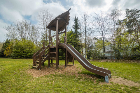 Parco giochi con scivolo e scale tra gli alberi al Buitencentrum Hessenheem, parco vacanze in Overijssel.