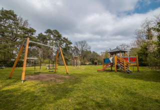 Aire de jeux au Buitencentrum Hessenheem, parc de vacances à Overijssel, Pays-Bas, avec balançoires et toboggan.