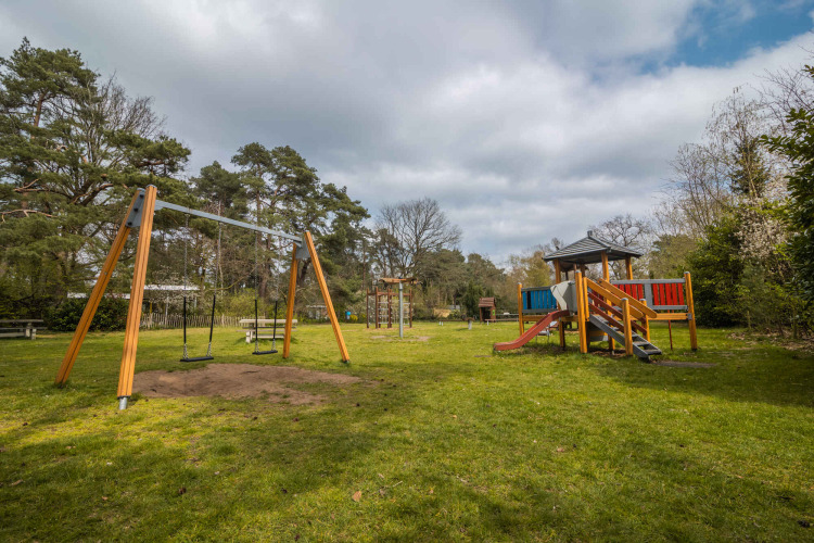 Playground at Buitencentrum Hessenheem, a holiday park in Overijssel, Netherlands, with swings and slide.