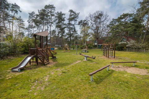 Aire de jeux avec toboggan, balançoires et structure d’escalade à Buitencentrum Hessenheem, Overijssel, Pays-Bas.