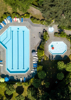 Luftaufnahme von Pools und Liegestühlen im Buitencentrum Hessenheem, umgeben von Bäumen in Overijssel.