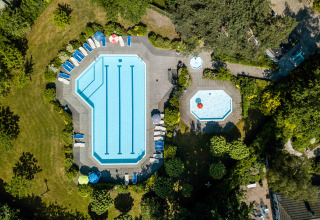 Luchtfoto van zwembaden en ligstoelen bij Buitencentrum Hessenheem, omgeven door bomen in Overijssel.