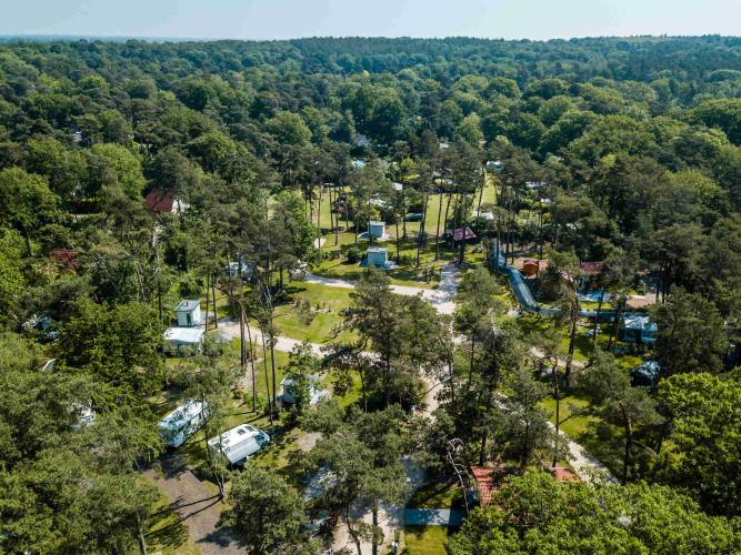 Aerial view of Buitencentrum Hessenheem holiday park surrounded by forest, caravans, and greenery in Overijssel.