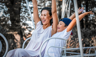 Eine Mutter und ihr Kind haben Spaß auf einer Fahrt in einem Ferienpark mit Glamping-Unterkünften.