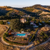 Aerial view of Agricola La Casetta holiday park, set among rolling hills and fields in Marche, Italy.