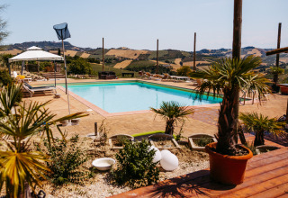 Outdoor swimming pool at Agricola La Casetta holiday park with rolling hill views in Marche, Italy.