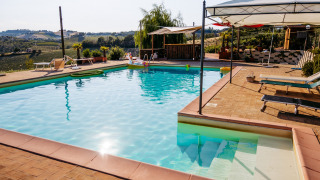 Piscina al aire libre en Agricola La Casetta, parque vacacional con vistas panorámicas en Marche, Italia.