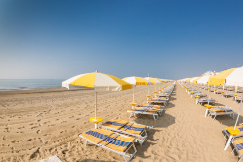 Rijen ligstoelen en parasols op een leeg zandstrand bij Montefiore dell'Aso, Marche, Italië.