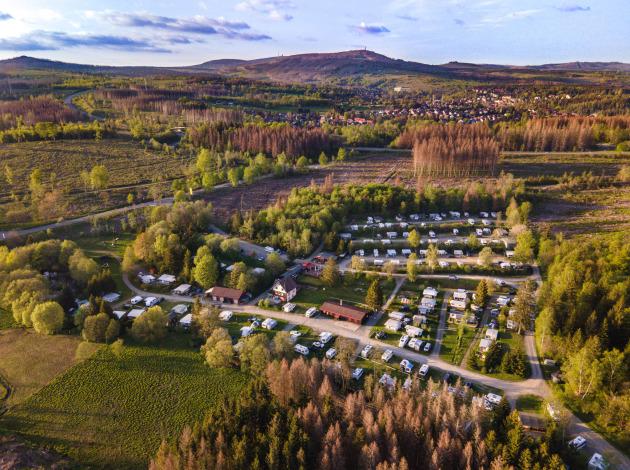 Luchtfoto van Camping Braunlage, een vakantiepark omringd door bossen en heuvels in Nedersaksen, Duitsland.