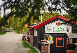 Ingresso del Camping Braunlage in Bassa Sassonia, Germania, con biciclette e ambiente boscoso.