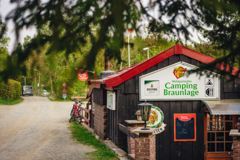 Eingang zum Campingplatz Braunlage in Niedersachsen, Deutschland, mit Fahrrädern und Wald.