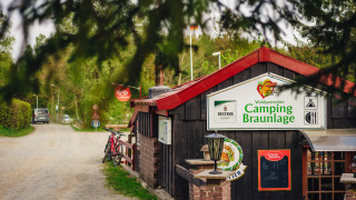 Entrada al Camping Braunlage en Baja Sajonia, Alemania, con bicicletas y entorno boscoso.