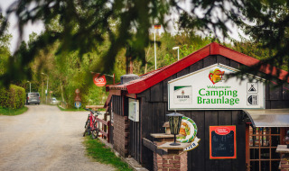 Entrada al Camping Braunlage en Baja Sajonia, Alemania, con bicicletas y entorno boscoso.