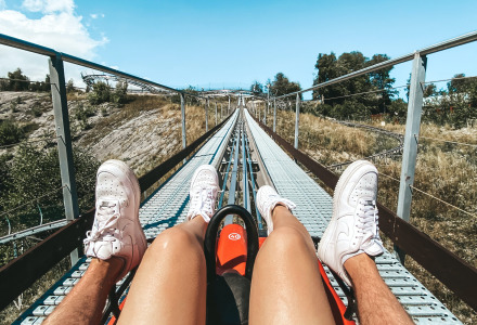 Dos personas en una montaña rusa alpina cerca de Braunlage, Alemania, disfrutando de un día soleado.