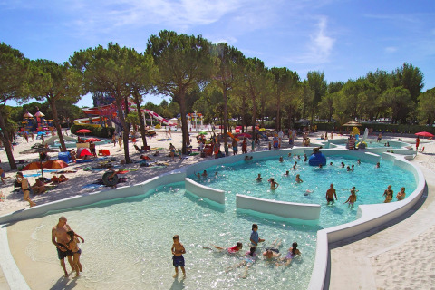 Visitantes disfrutan de la piscina y áreas de juego acuáticas en Union Lido Mare, parque vacacional en Veneto, Italia.