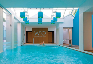 Piscina coperta al W10 Leisure Building del Camping Union Lido Mare, Veneto, Italia, dal design moderno e blu.
