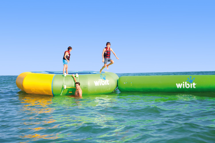 Kinderen spelen op een Wibit waterpark bij Camping Union Lido Mare, Veneto, Italië, onder een heldere lucht.